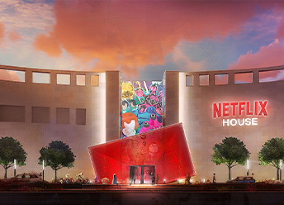 Illustration d'un bâtiment moderne nommé 'Netflix House', avec une façade lumineuse et artistique, un panneau Netflix visible, entouré de végétation et illuminé par un ciel coloré au coucher du soleil."